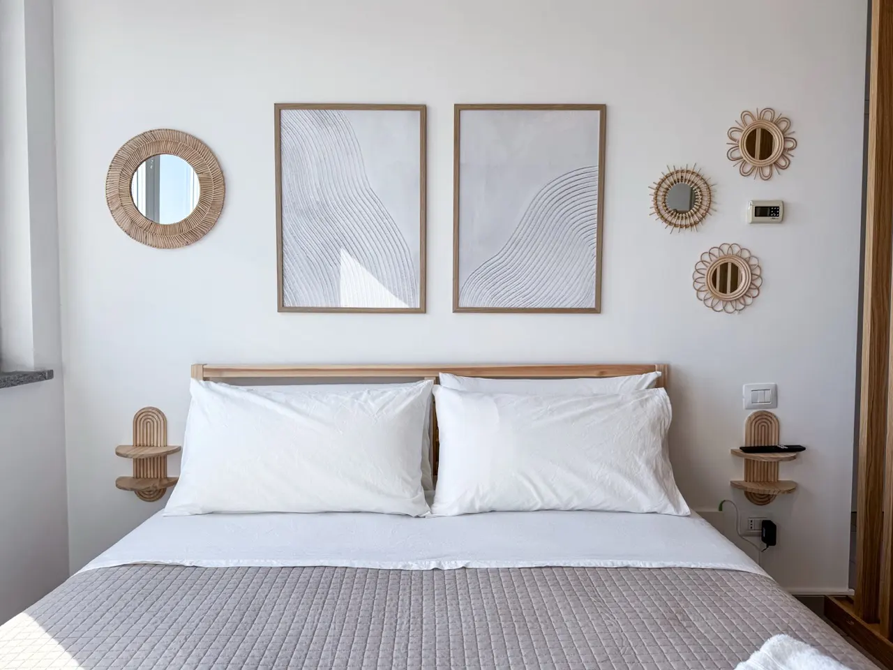 Bed headboard with rattan mirrors and art prints